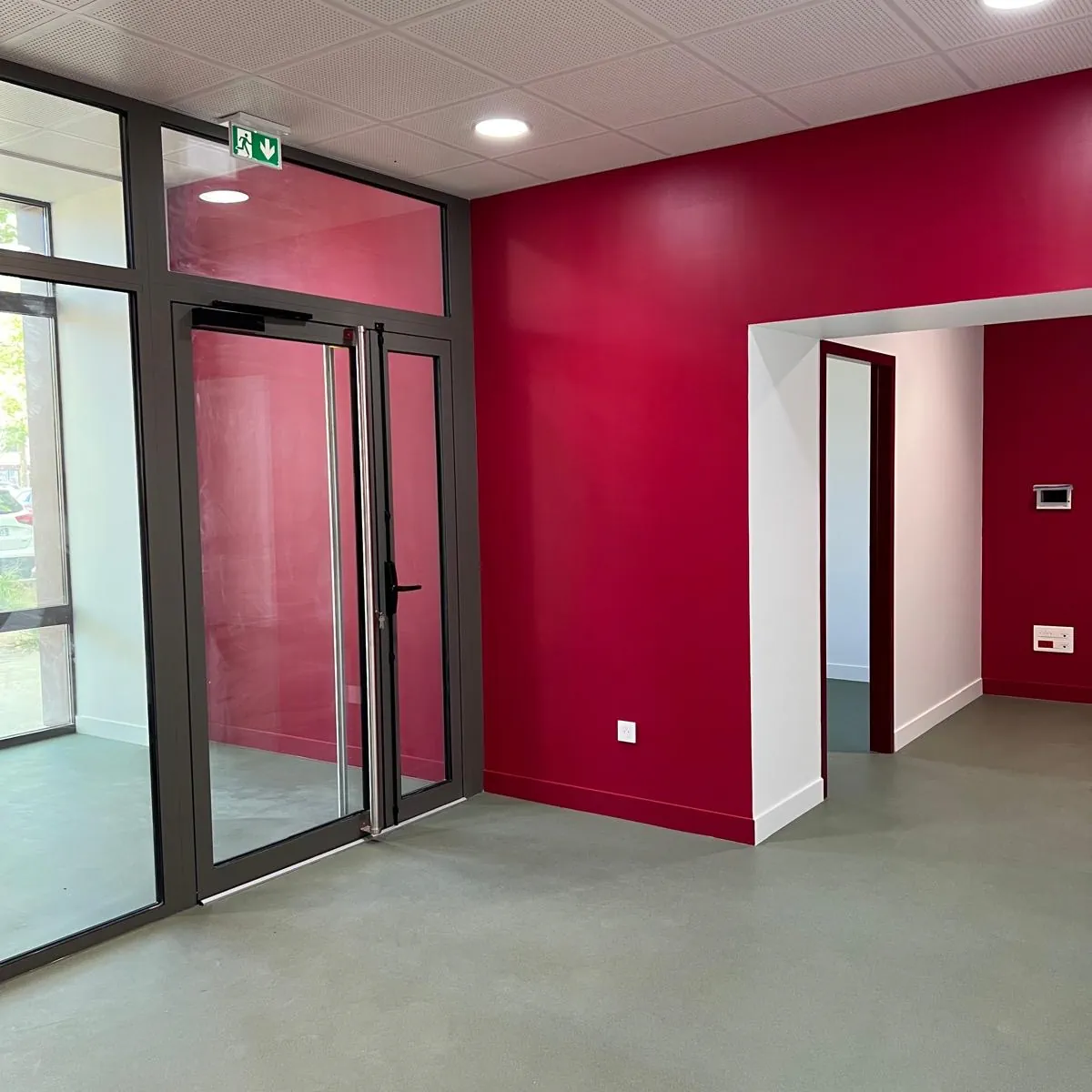 Incubateur d'entreprises à Nevers — entrée vitrée et mur rouge
